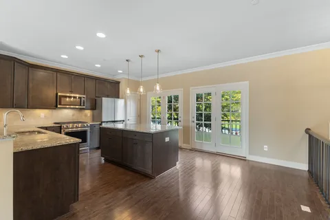 a large kitchen with stainless steel appliances granite countertop a large stove a sink dishwasher and a refrigerator with wooden floor