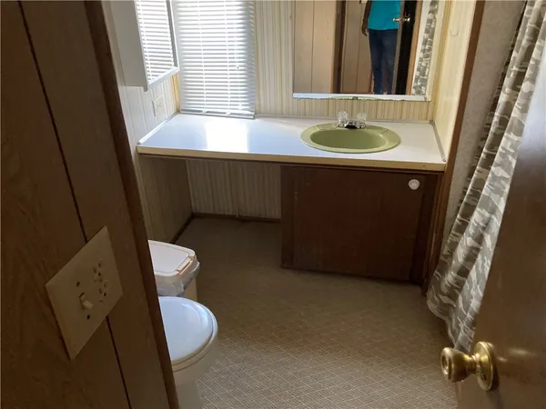 a bathroom with a sink a toilet and a mirror