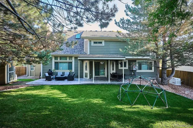 a view of a house with a backyard and a patio