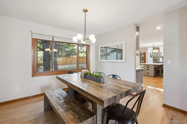 a view of a dining room and livingroom with furniture wooden floor a chandelier