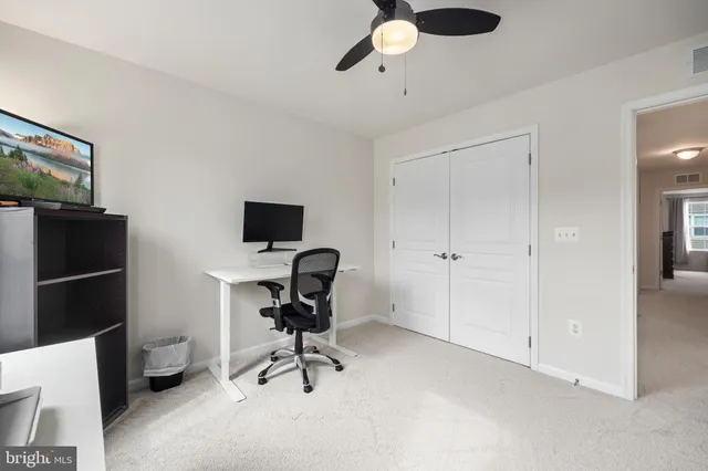 a view of a workspace with furniture and a window