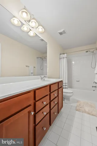 a spacious bathroom with a granite countertop sink a mirror and a shower
