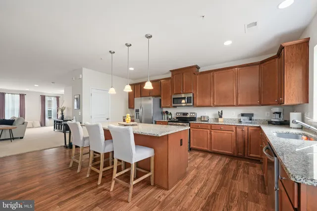 a kitchen with a table chairs stove and wooden floor