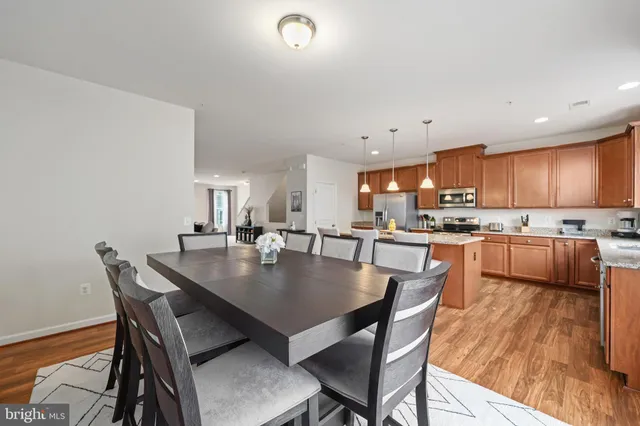 a kitchen with a dining table chairs and wooden floor