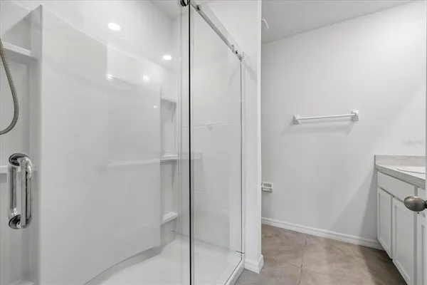 a bathroom with a shower and a glass door