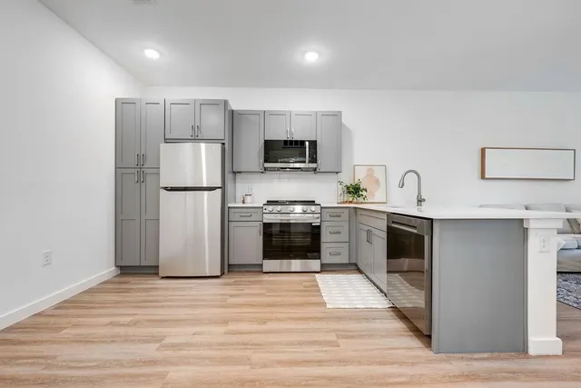 a kitchen with a refrigerator and a stove top oven