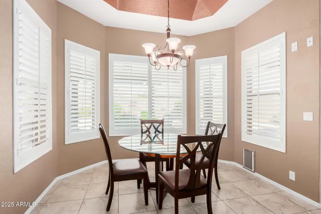 a kitchen with stainless steel appliances kitchen island granite countertop a dining table chairs and a refrigerator