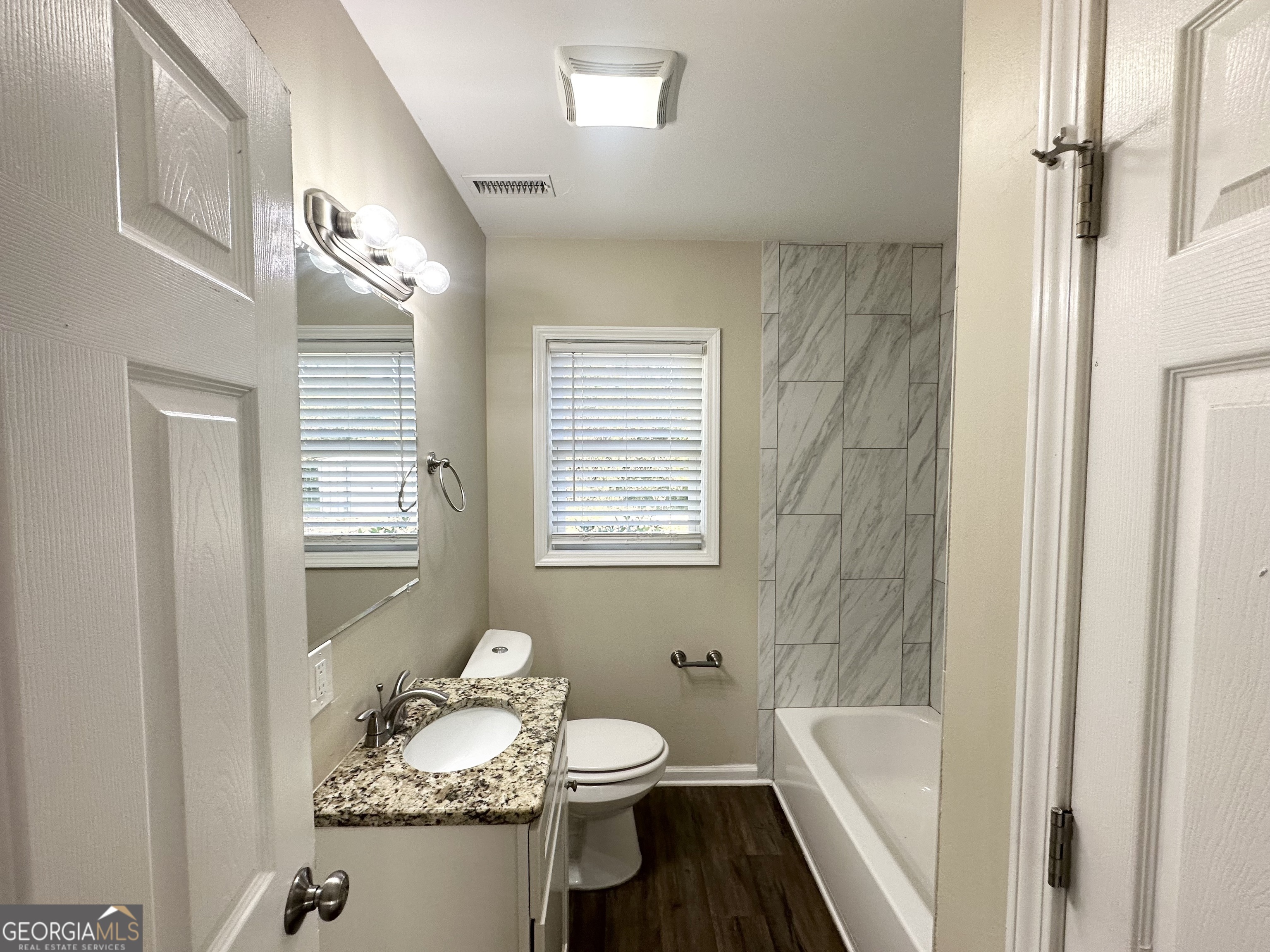 3438 Maryvale Drive Decatur, GA 30032 - Photo 8 of 13 a bathroom with a granite countertop sink toilet a mirror and shower