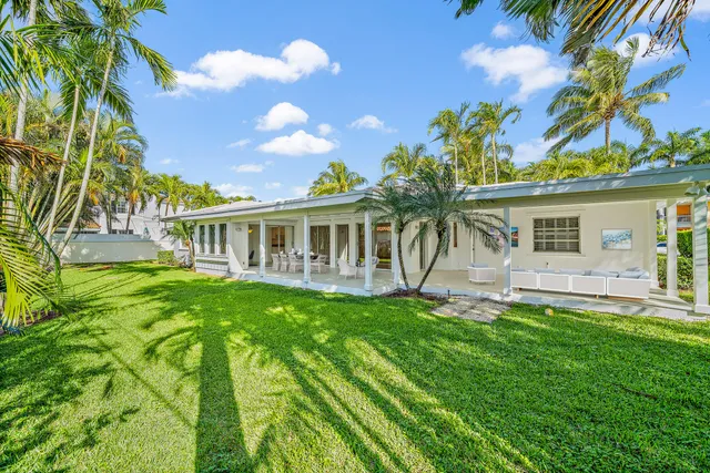 a front view of a house with a yard and potted plants