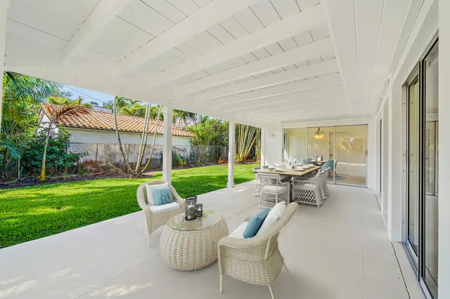 a view of a patio with table and chairs next to a yard