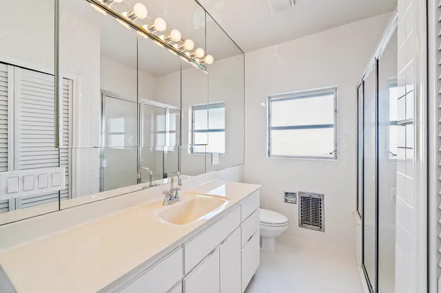 a bathroom with a sink a toilet and a large mirror