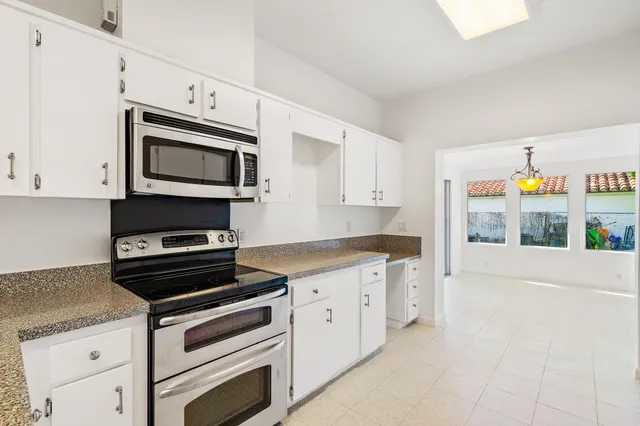 a kitchen with stainless steel appliances granite countertop a stove microwave and cabinets