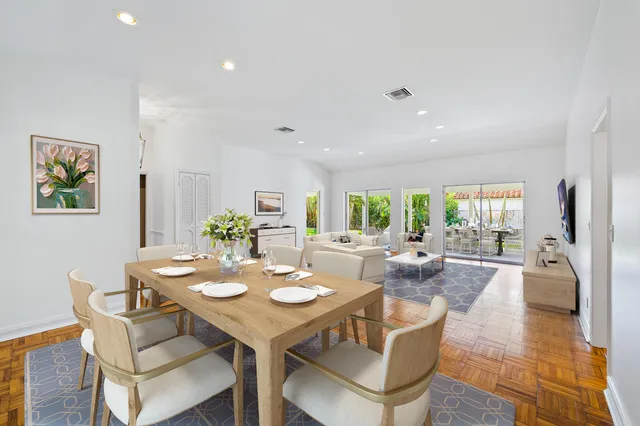 a view of a dining room and livingroom view with furniture wooden floor and a rug