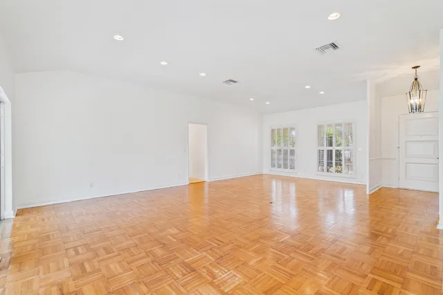 a view of an empty room with wooden floor