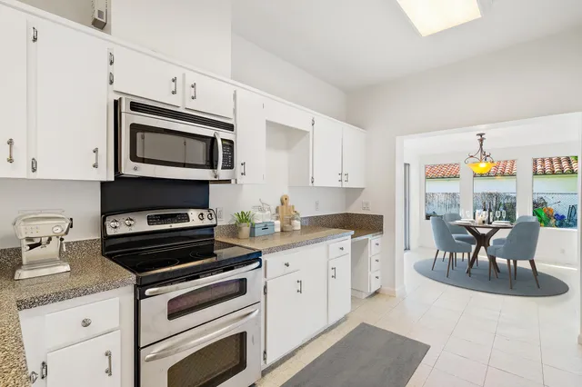 a kitchen with granite countertop a stove top oven microwave and cabinets