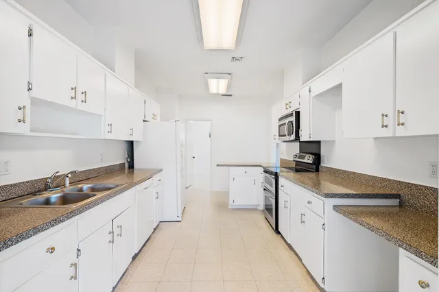 a kitchen with granite countertop a sink and a stove