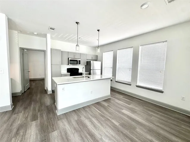 a view of a kitchen with wooden floor and a ceiling fan