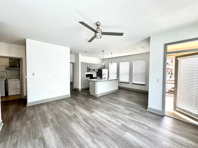 a view of a kitchen with wooden floor and a ceiling fan