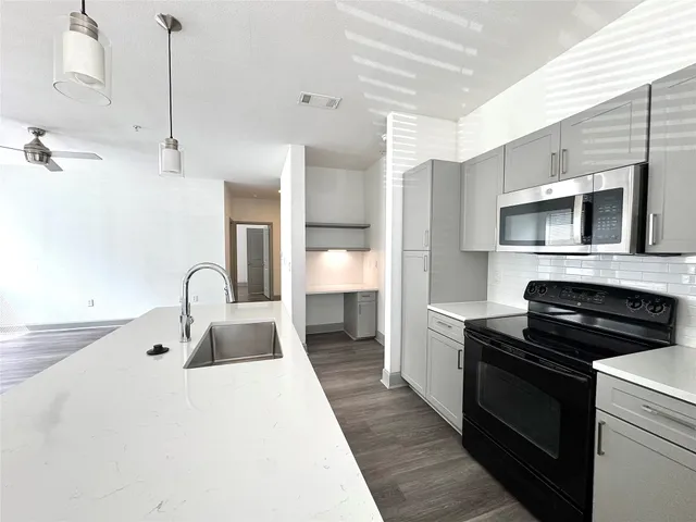 a kitchen with a sink stove and cabinets