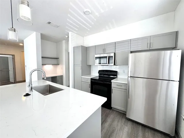 a kitchen with stainless steel appliances a refrigerator sink and microwave