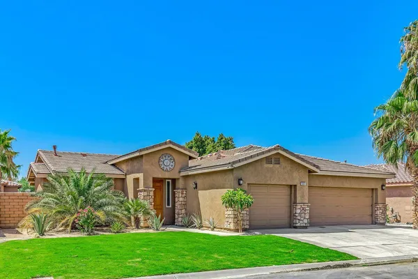 a front view of a house with a garden and plants