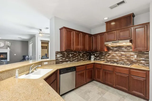 a kitchen with stainless steel appliances granite countertop a sink stove and cabinets