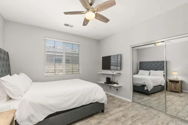 a bedroom with a bed window and a flat screen tv
