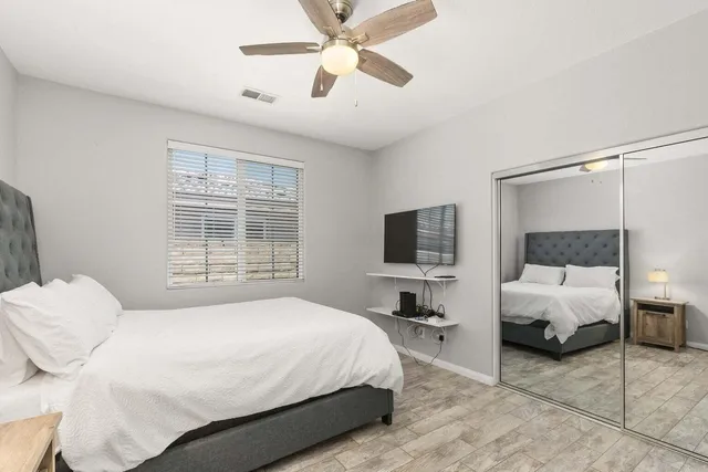 a bedroom with a bed window and a flat screen tv