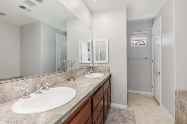 a bathroom with a granite countertop sink and a mirror