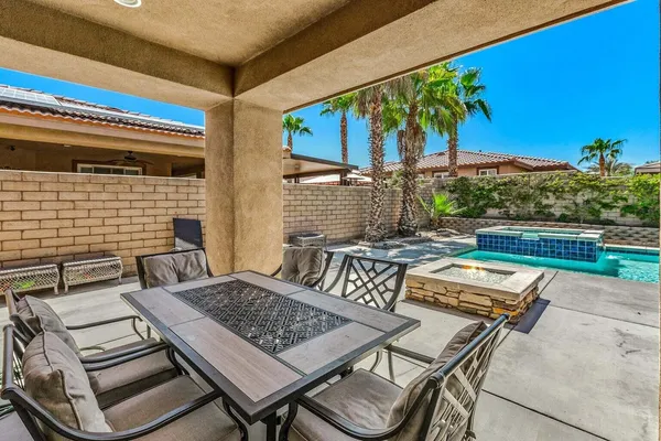 a view of a patio with couple of chairs and a fire pit