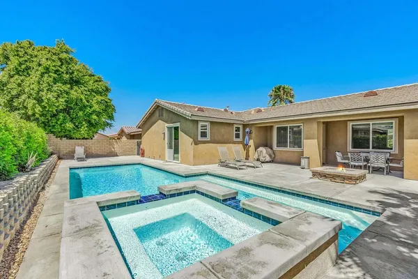 a view of a house with pool and sitting area