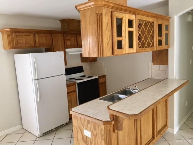 1606 East Quail Street Pharr, TX 78577 - Photo 5 of 10 a kitchen with stainless steel appliances granite countertop a refrigerator a sink and a stove