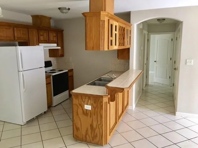 a kitchen with stainless steel appliances granite countertop a refrigerator and a stove