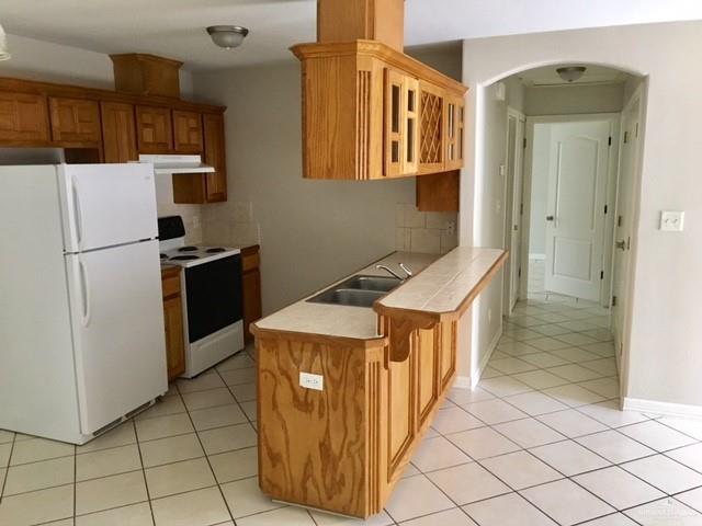1606 East Quail Street Pharr, TX 78577 - Photo 6 of 10 a kitchen with stainless steel appliances granite countertop a refrigerator and a stove