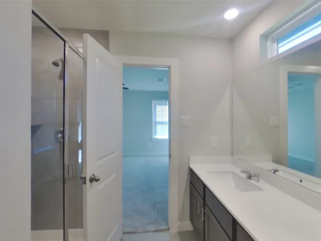 a bathroom with a shower sink and mirror