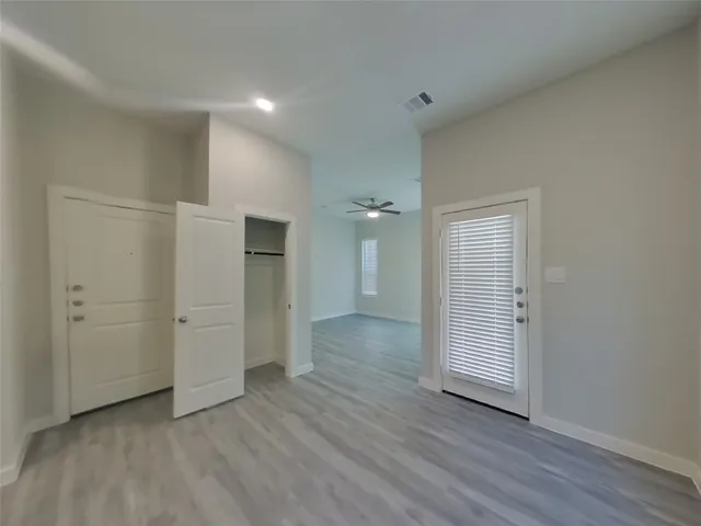 an empty room with closet and wooden floor
