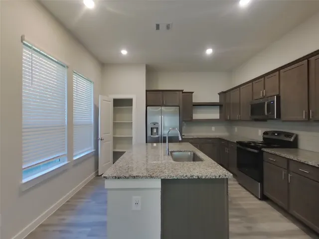 a kitchen with stainless steel appliances granite countertop a sink stove and refrigerator