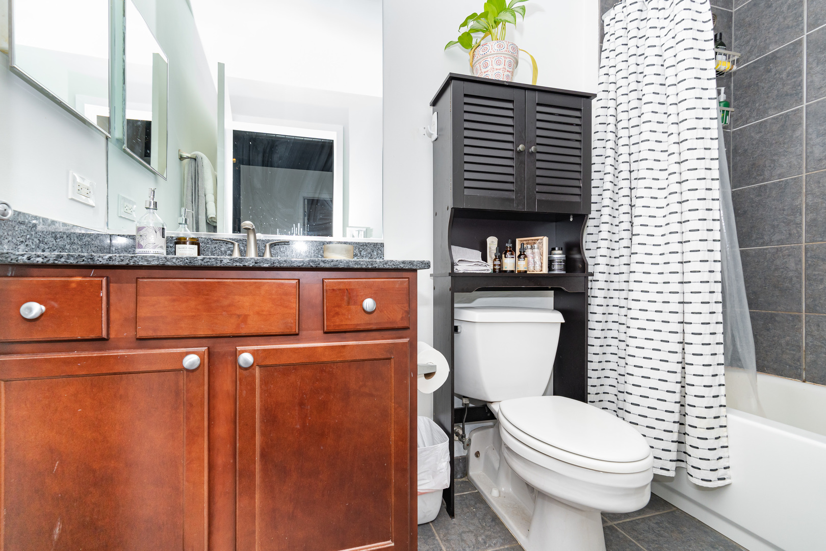 1069 West 14th Place, Unit 305 Chicago, IL 60608 - Photo 12 of 26 a bathroom with a granite countertop toilet a sink and a bathtub