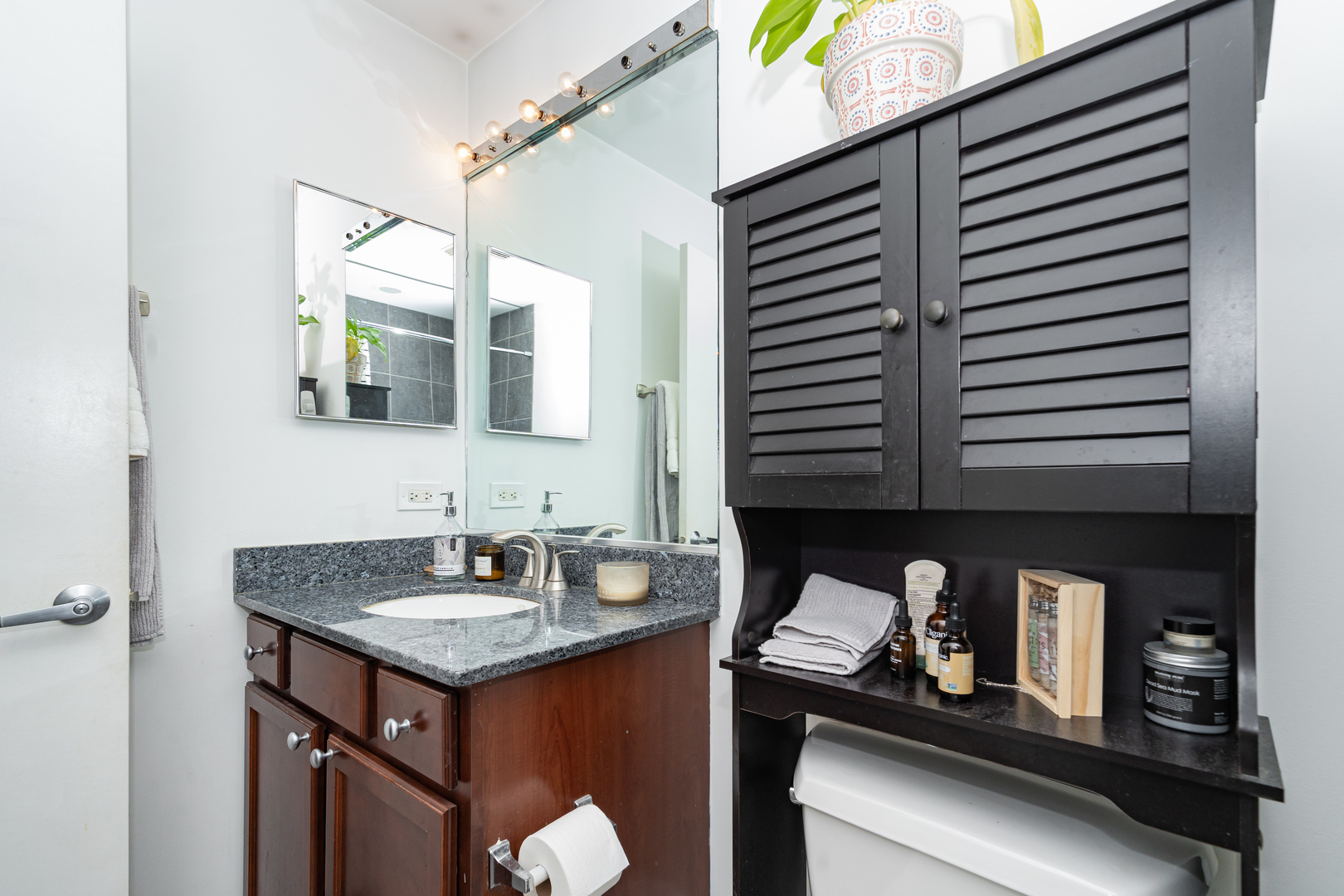 1069 West 14th Place, Unit 305 Chicago, IL 60608 - Photo 13 of 26 a bathroom with a granite countertop sink and a mirror