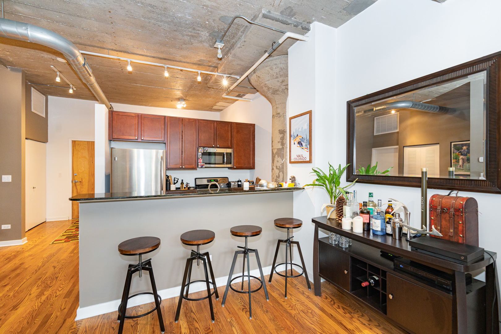 1069 West 14th Place, Unit 305 Chicago, IL 60608 - Photo 6 of 26 a kitchen with granite countertop a table chairs stove and cabinets