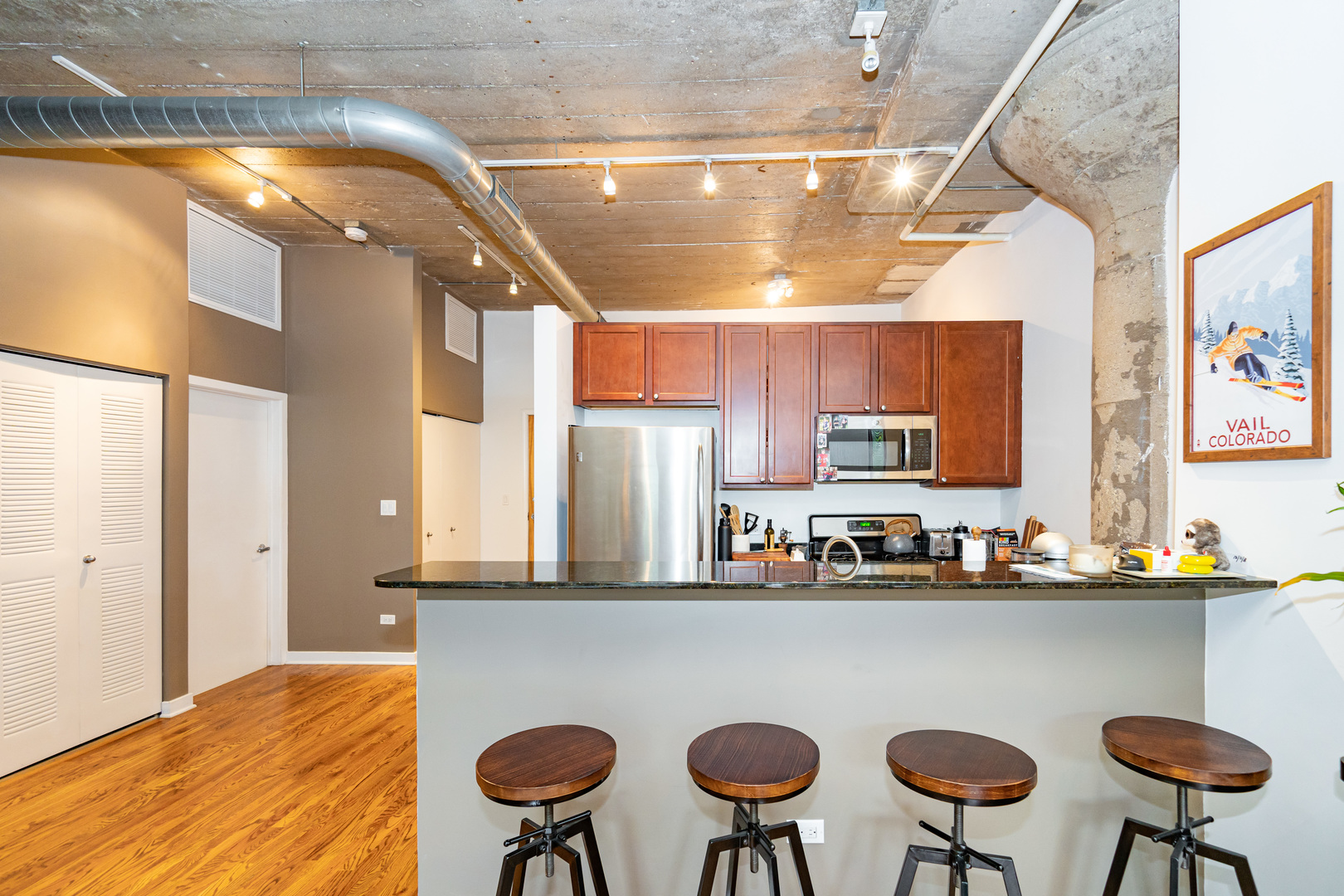 1069 West 14th Place, Unit 305 Chicago, IL 60608 - Photo 7 of 26 a dining room with stainless steel appliances kitchen island a table and chairs