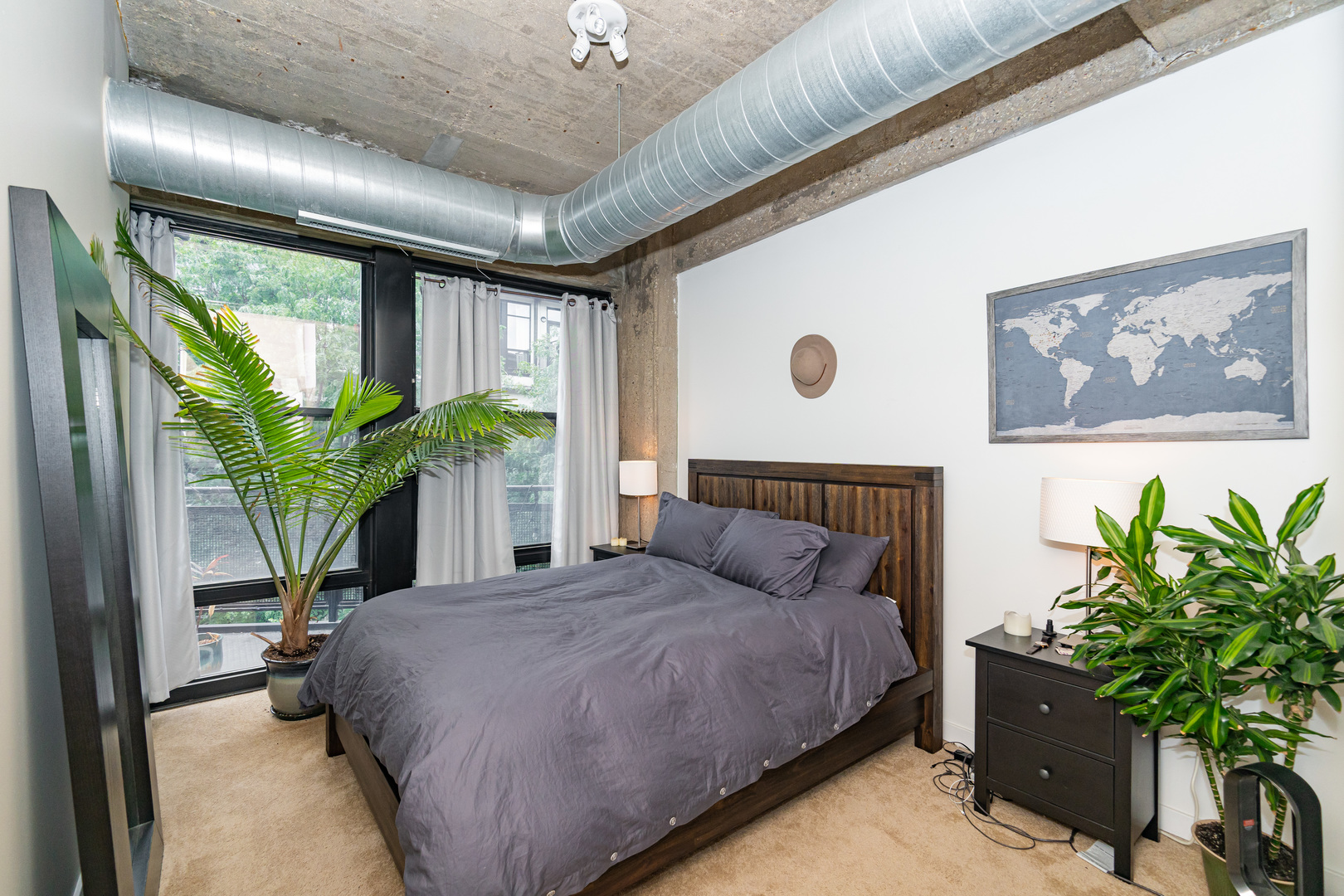 1069 West 14th Place, Unit 305 Chicago, IL 60608 - Photo 10 of 26 a bedroom with a large bed and a potted plant