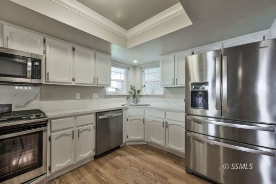 1113 Amie Court Ridgecrest, CA 93555 - Photo 5 of 33 a kitchen with stainless steel appliances granite countertop a stove a refrigerator and a microwave