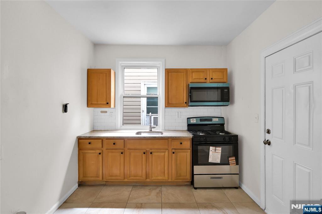 491 South 17th Street Newark, NJ 07103 - Photo 16 of 22 a kitchen with a stove and a microwave