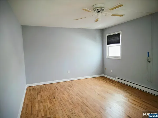 an empty room with a window and a ceiling fan