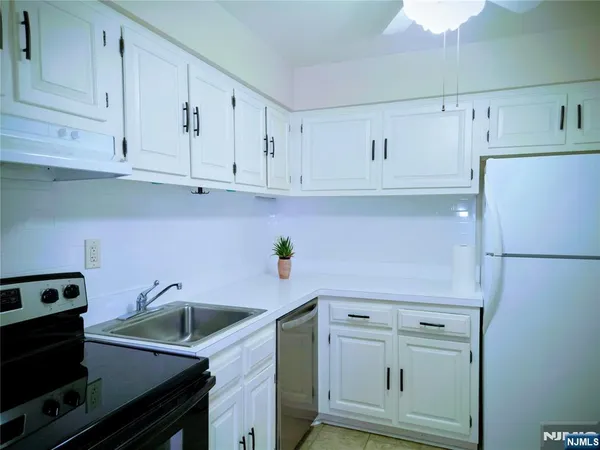 a kitchen with white cabinets and white appliances