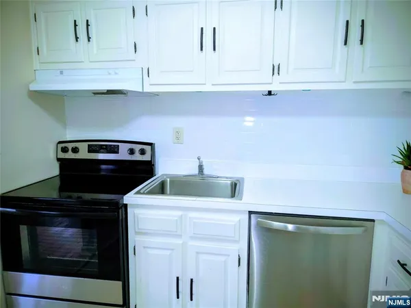 a kitchen with white cabinets and appliances