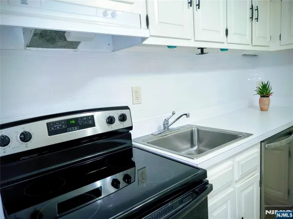 a kitchen with a stove and a white cabinets