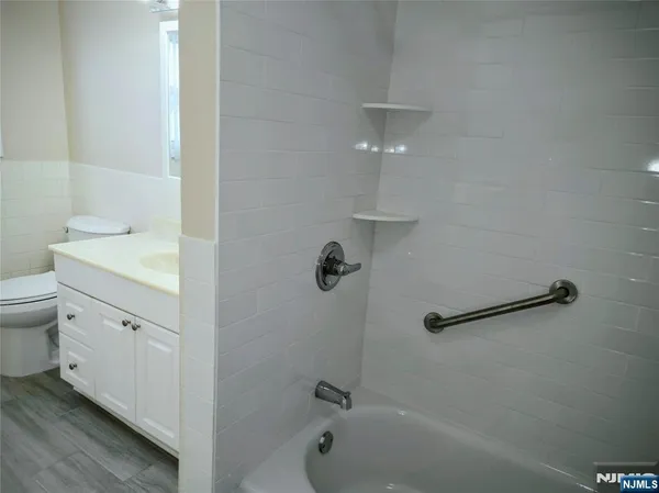 a bathroom with a granite countertop sink a toilet and shower