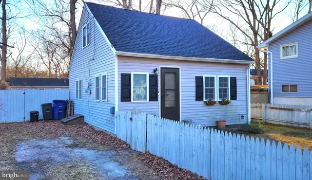a view of a house with a yard and wooden fence